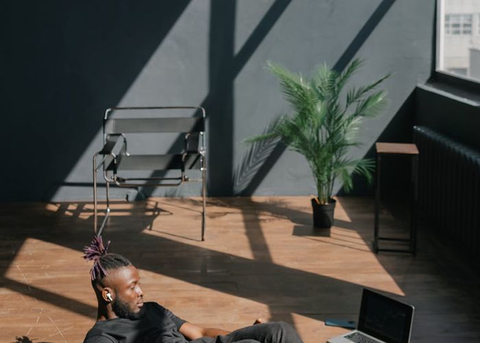A focused man doing floor exercises on a mat in a bright living room.